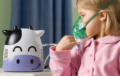 Девочка дышит через детский небулайзер